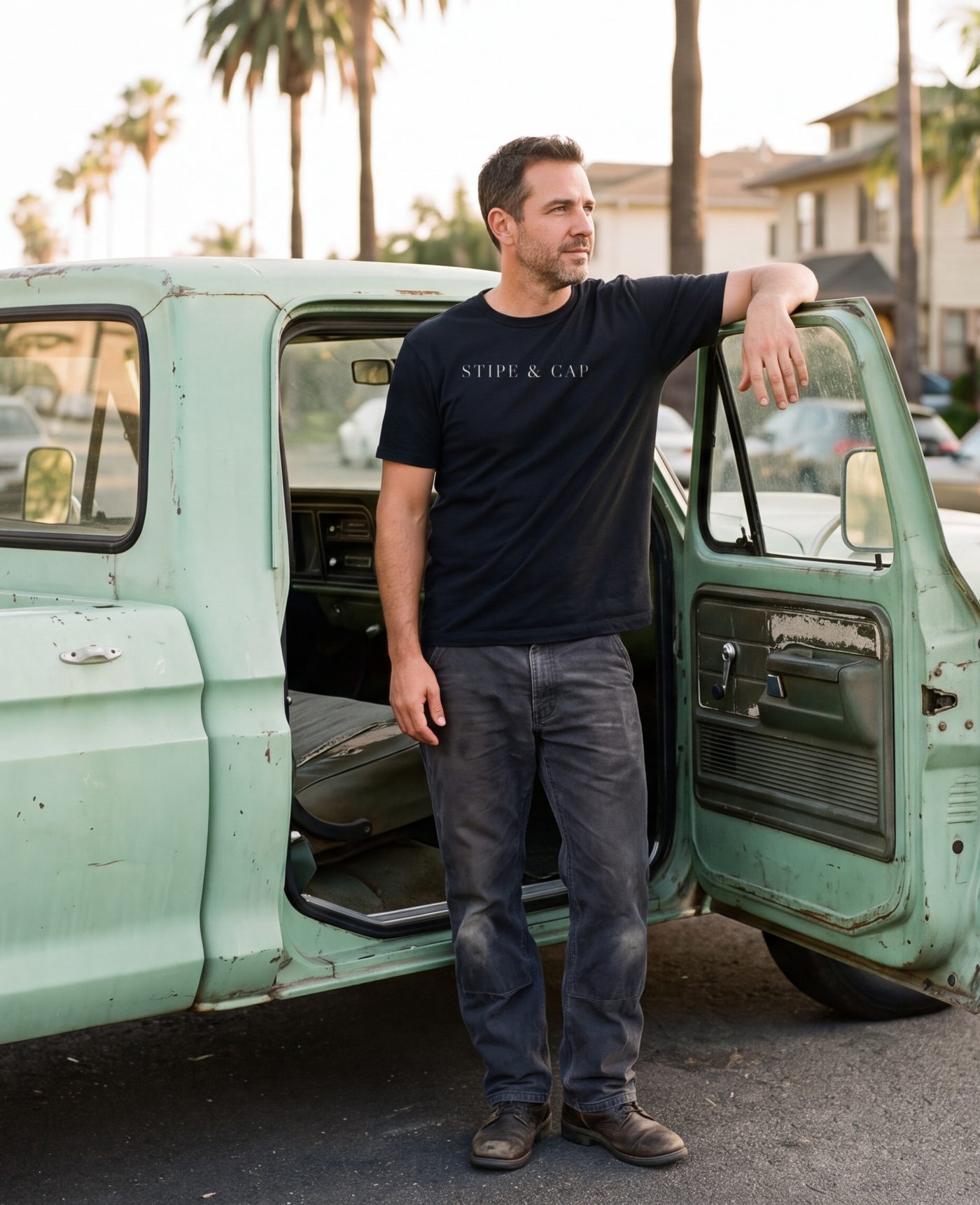 The near-black tee worn beside an old pickup truck.